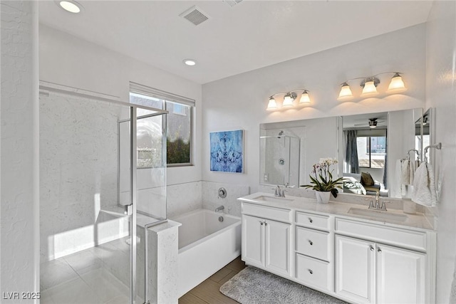 bathroom with a garden tub, a shower stall, visible vents, and a sink