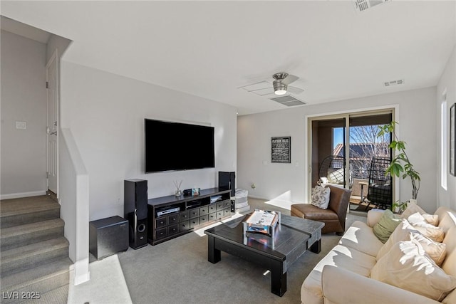 living room featuring carpet floors, visible vents, stairway, and a ceiling fan