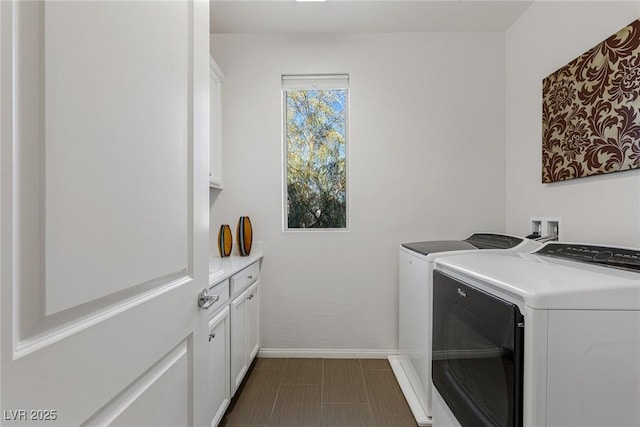 laundry room with separate washer and dryer, cabinet space, and baseboards