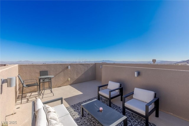 view of patio / terrace with a balcony, a mountain view, and an outdoor hangout area