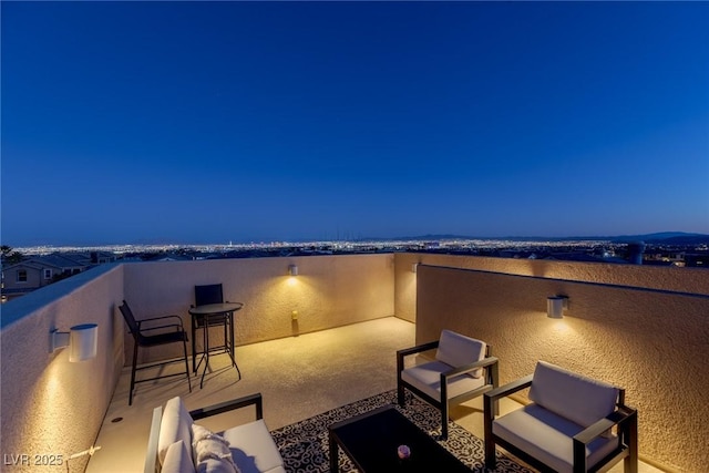 patio terrace at dusk with a balcony and an outdoor hangout area