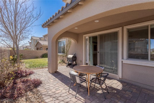 view of patio featuring outdoor dining space, a fenced backyard, and a grill