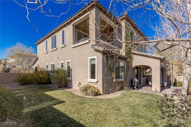 back of house with a patio area, a yard, fence, and stucco siding