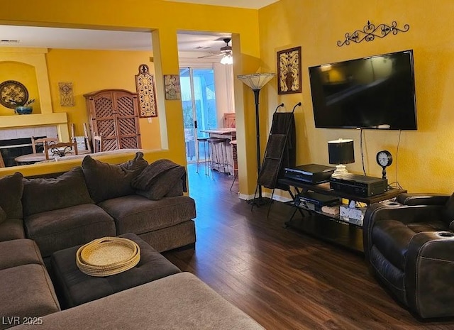 living area with ceiling fan, baseboards, wood finished floors, and a tile fireplace