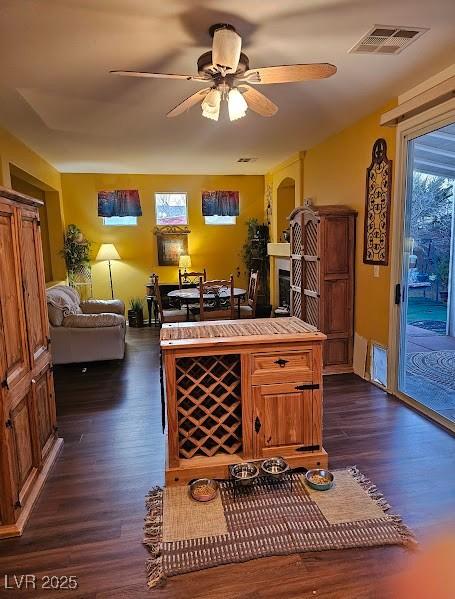 interior space with dark wood-style flooring, visible vents, and ceiling fan