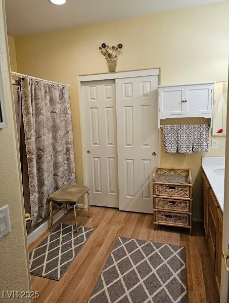 bathroom with curtained shower, wood finished floors, and vanity