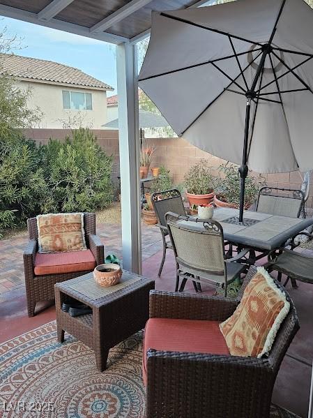 view of patio / terrace featuring fence, an outdoor hangout area, and outdoor dining space