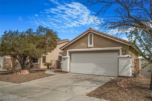 view of front facade with an attached garage, fence, driveway, a tiled roof, and stucco siding