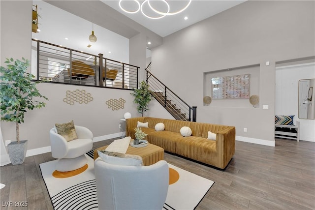 living area with stairs, recessed lighting, baseboards, and wood finished floors