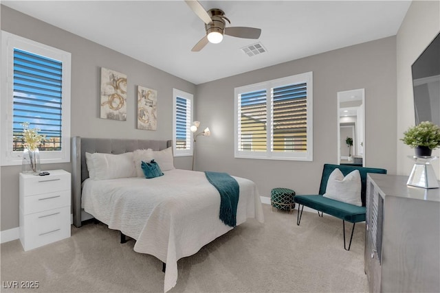 bedroom with ceiling fan, visible vents, baseboards, and light colored carpet