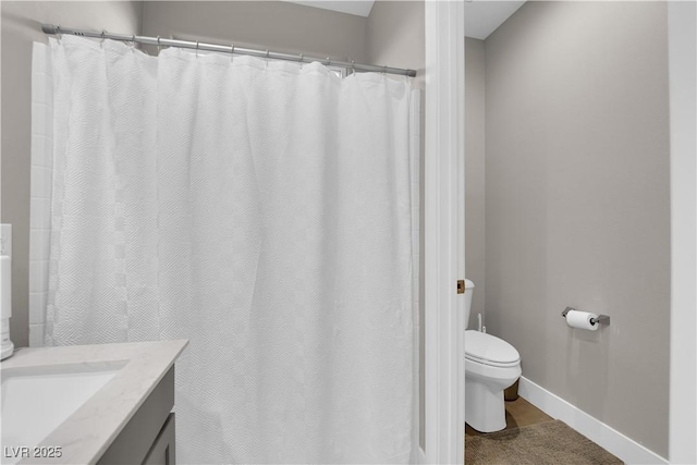 full bath with vanity, toilet, and baseboards