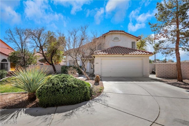 mediterranean / spanish house featuring an attached garage, fence, a tile roof, concrete driveway, and stucco siding