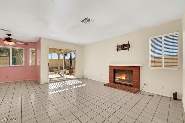 unfurnished living room with light tile patterned floors, ceiling fan, a brick fireplace, and visible vents