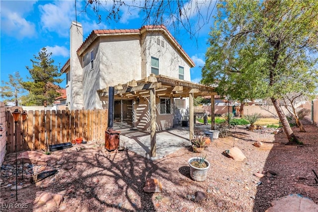 rear view of property featuring a fenced backyard, a chimney, a patio area, a pergola, and stucco siding