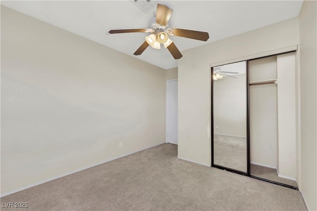 unfurnished bedroom with light carpet, ceiling fan, a closet, and visible vents