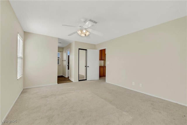 unfurnished bedroom featuring baseboards, a ceiling fan, and light colored carpet