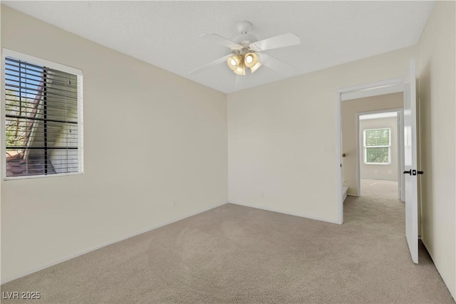 spare room featuring ceiling fan and light colored carpet