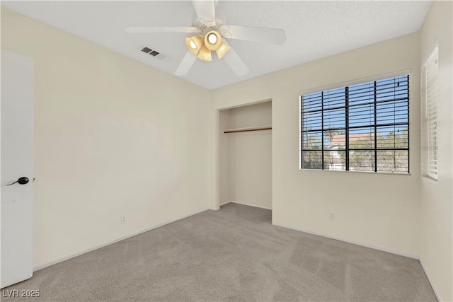 unfurnished bedroom with a ceiling fan, light colored carpet, a closet, and visible vents