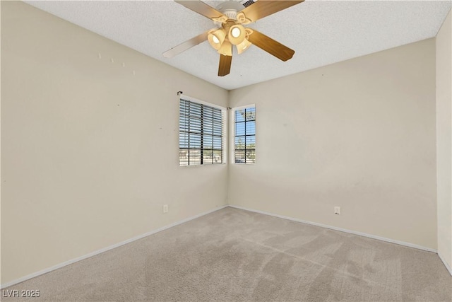 unfurnished room with light carpet, ceiling fan, a textured ceiling, and baseboards