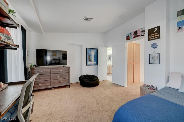 carpeted bedroom featuring ensuite bath and visible vents