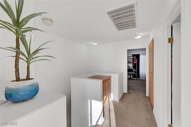 corridor featuring light carpet, an upstairs landing, visible vents, and baseboards