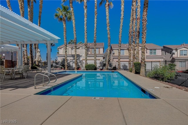 pool with a residential view, fence, and a patio