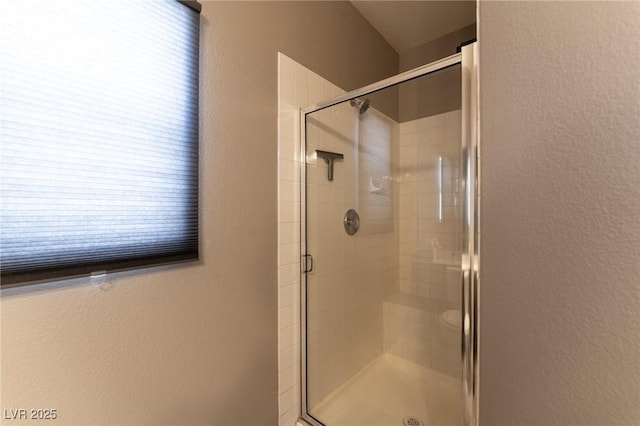 full bath with a stall shower and a textured wall