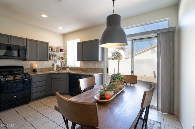 kitchen with light stone counters, gray cabinetry, light tile patterned flooring, and black appliances