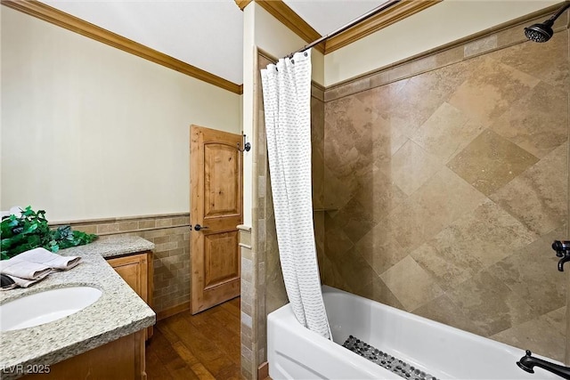 bathroom with a wainscoted wall, shower / tub combo with curtain, crown molding, vanity, and tile walls