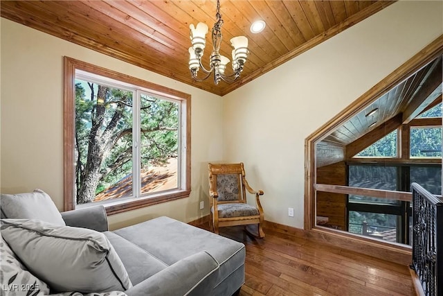 living area with ornamental molding, wood finished floors, wood ceiling, and a notable chandelier