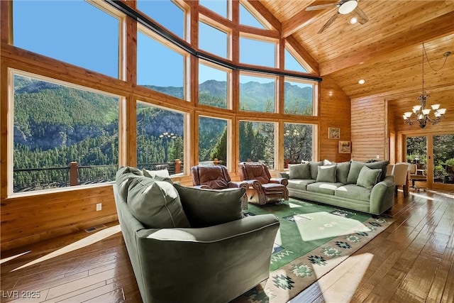 living room featuring dark wood finished floors, wood ceiling, and wooden walls