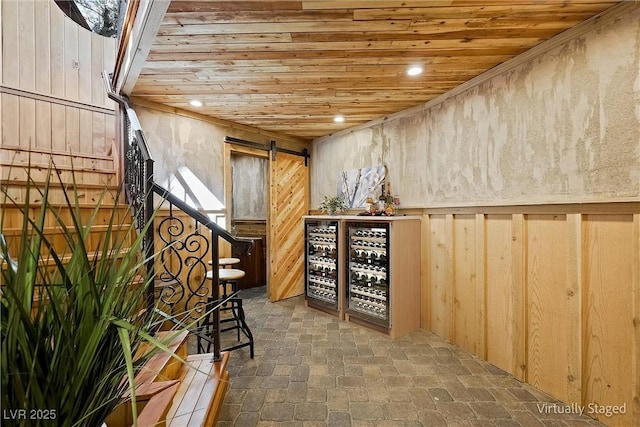 wine cellar featuring wooden ceiling, a barn door, brick floor, and recessed lighting