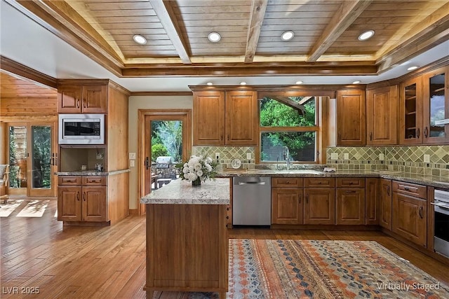 kitchen featuring wooden ceiling, stainless steel appliances, light wood-style floors, brown cabinets, and glass insert cabinets