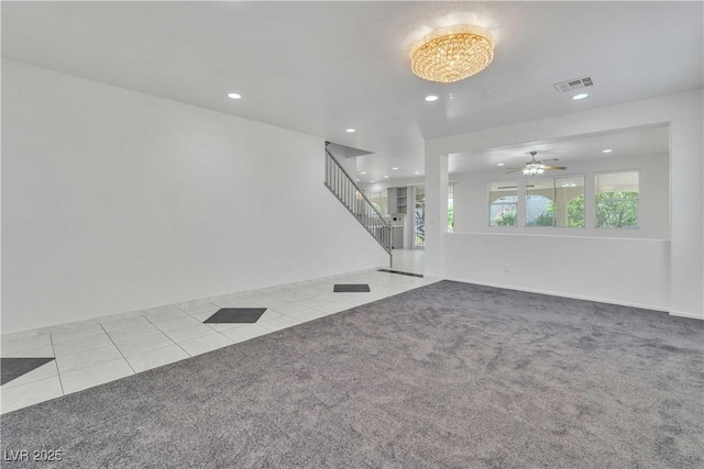 unfurnished living room with light carpet, light tile patterned floors, stairs, and recessed lighting