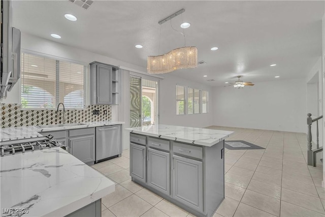 kitchen featuring a sink, a kitchen island, stainless steel dishwasher, open shelves, and decorative light fixtures