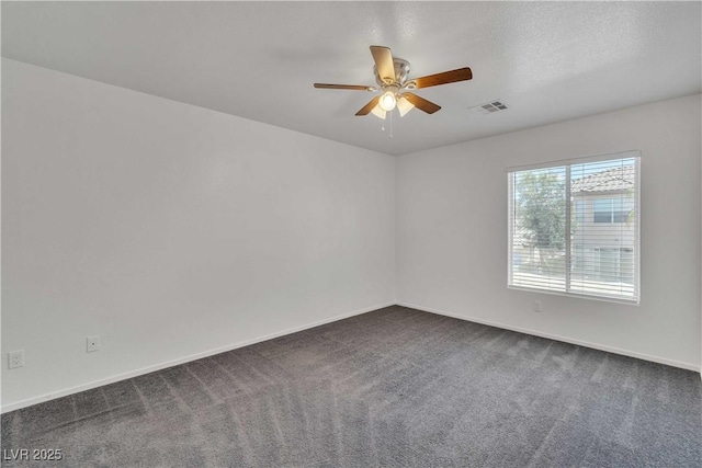 carpeted spare room featuring baseboards, visible vents, and a ceiling fan