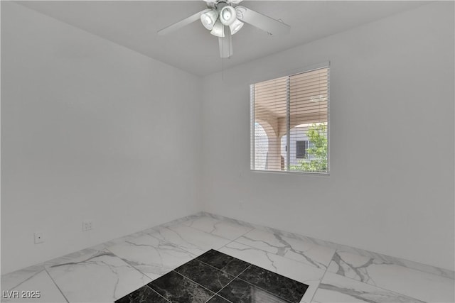 empty room featuring marble finish floor and a ceiling fan