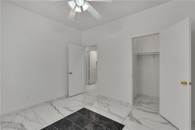 unfurnished bedroom featuring ceiling fan, marble finish floor, and a closet