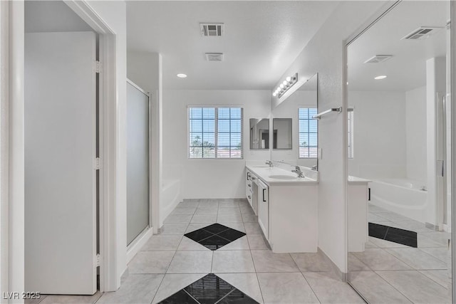 full bath with tile patterned flooring, visible vents, a garden tub, and double vanity