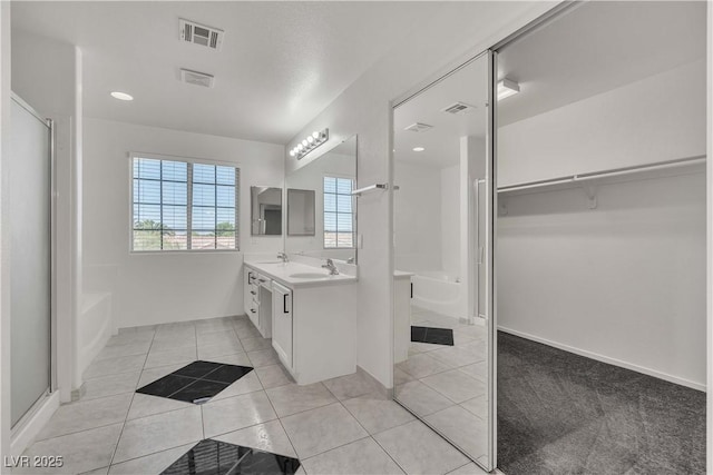 full bath featuring double vanity, a sink, visible vents, and tile patterned floors