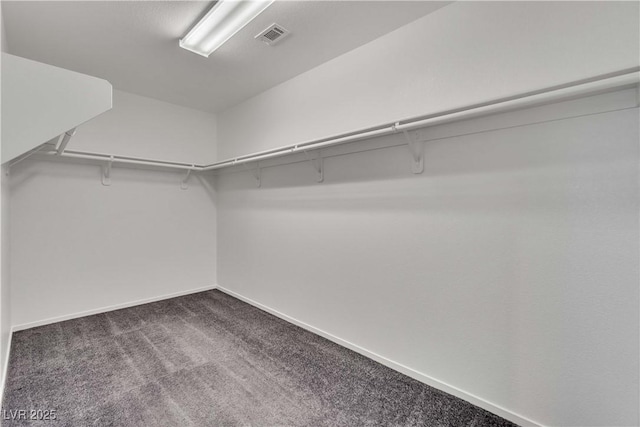 walk in closet with visible vents and dark carpet