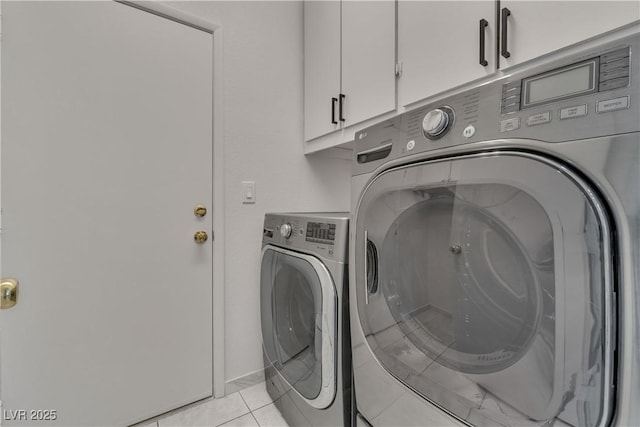 clothes washing area featuring cabinet space, light tile patterned floors, and separate washer and dryer