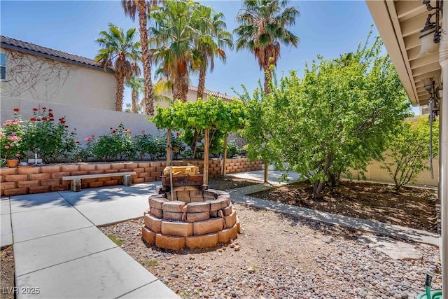 view of yard featuring fence, a fire pit, and a patio