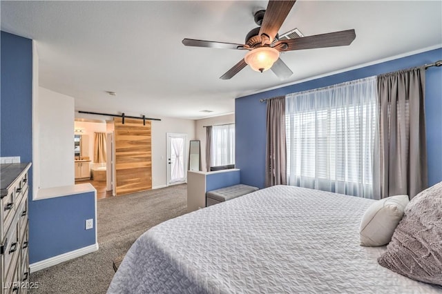 bedroom with a barn door, dark colored carpet, and a ceiling fan