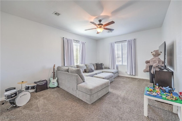 carpeted living room featuring baseboards, visible vents, and a ceiling fan