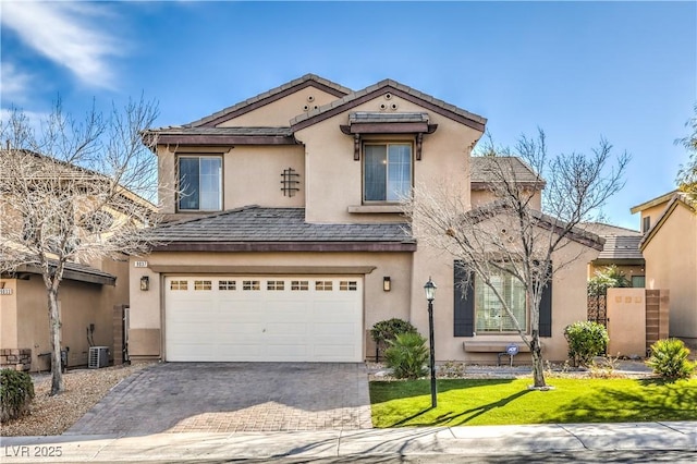 view of front of property with decorative driveway, an attached garage, a front yard, and stucco siding