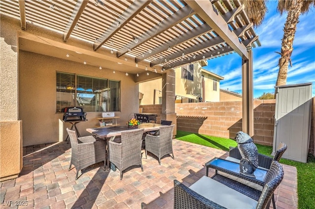 view of patio featuring outdoor dining space, fence, and a pergola