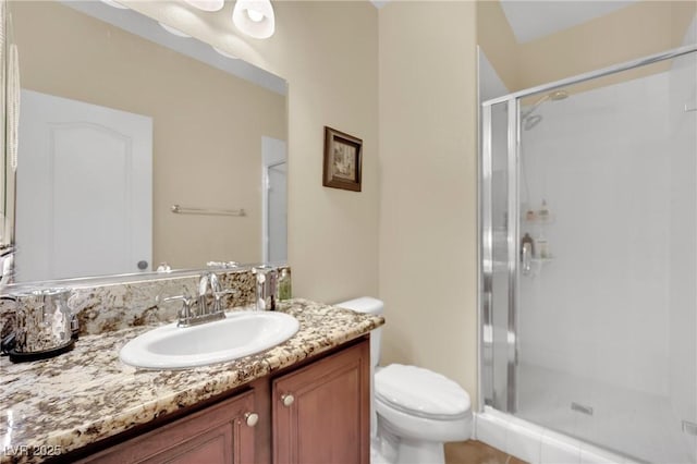 bathroom featuring a stall shower, vanity, and toilet