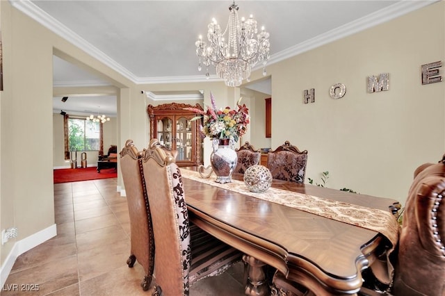 dining area with an inviting chandelier, light tile patterned floors, baseboards, and crown molding