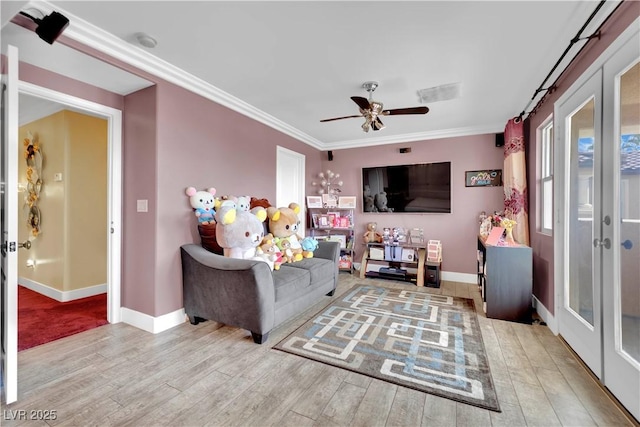 living room featuring ornamental molding, french doors, light wood finished floors, and baseboards